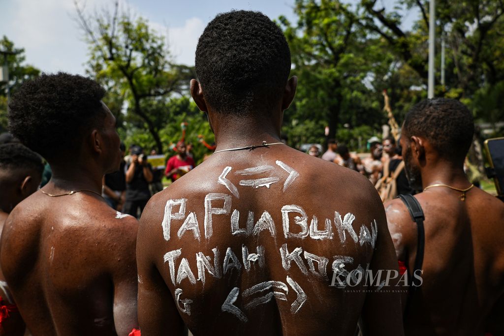 Perwakilan masyarakat adat suku Awyu dan Moi dari Papua menuliskan kalimat kritik di punggungnya saat mengikuti aksi damai di depan Gedung Mahkamah Agung, Jakarta, Senin (22/7/2024). 