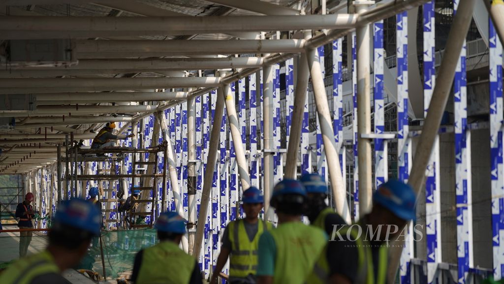 Pekerja merampungkan pembangunan jembatan penghubung Stasiun LRT Jabodebek Halim dengan Stasiun Halim di Makasar, Jakarta Timur, Rabu (17/5/2023). Stasiun Halim dengan luas 41.447 meter persegi merupakan titik keberangkatan dan kedatangan Kereta Cepat Jakarta-Bandung dari Jakarta.