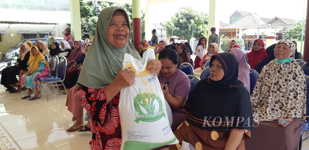 Warga Desa Entalsewu, Kecamatan Buduran, Kabupaten Sidoarjo, Jawa Timur, menerima bantuan beras untuk penanggulangan kemiskinan, Senin (3/6/2024). 