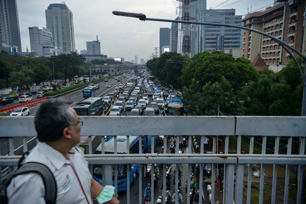 Pekerja melihat kemacetan yang terjadi di Jalan Gatot Subroto, Jakarta, Senin (19/6/2023). Ekonomi Indonesia triwulan I-2023 tumbuh 5,03 persen dibandingkan dengan triwulan I-2022 secara <i>year on year</i>. 