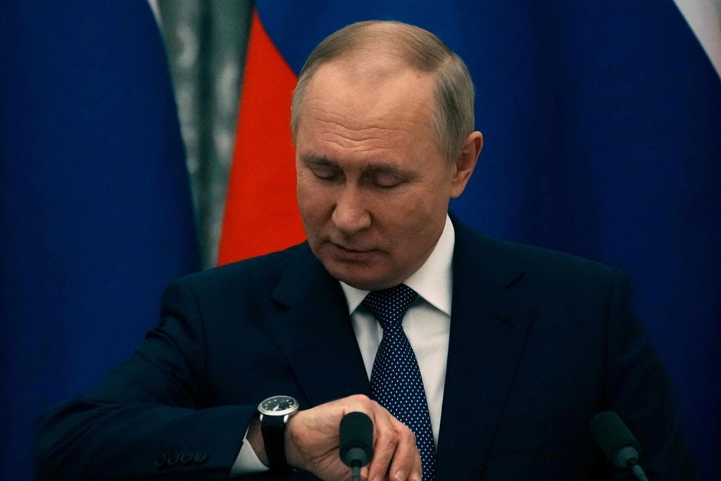 Presiden Rusia Vladimir Putin memeriksa arlojinya sebelum konferensi pers dengan Presiden Perancis Emmanuel Macron di Moskwa pada 7 Februari 2022. Macron berharap bisa membuat awal menuju deeskalasi ketegangan di Ukraina saat bertemu Putin.