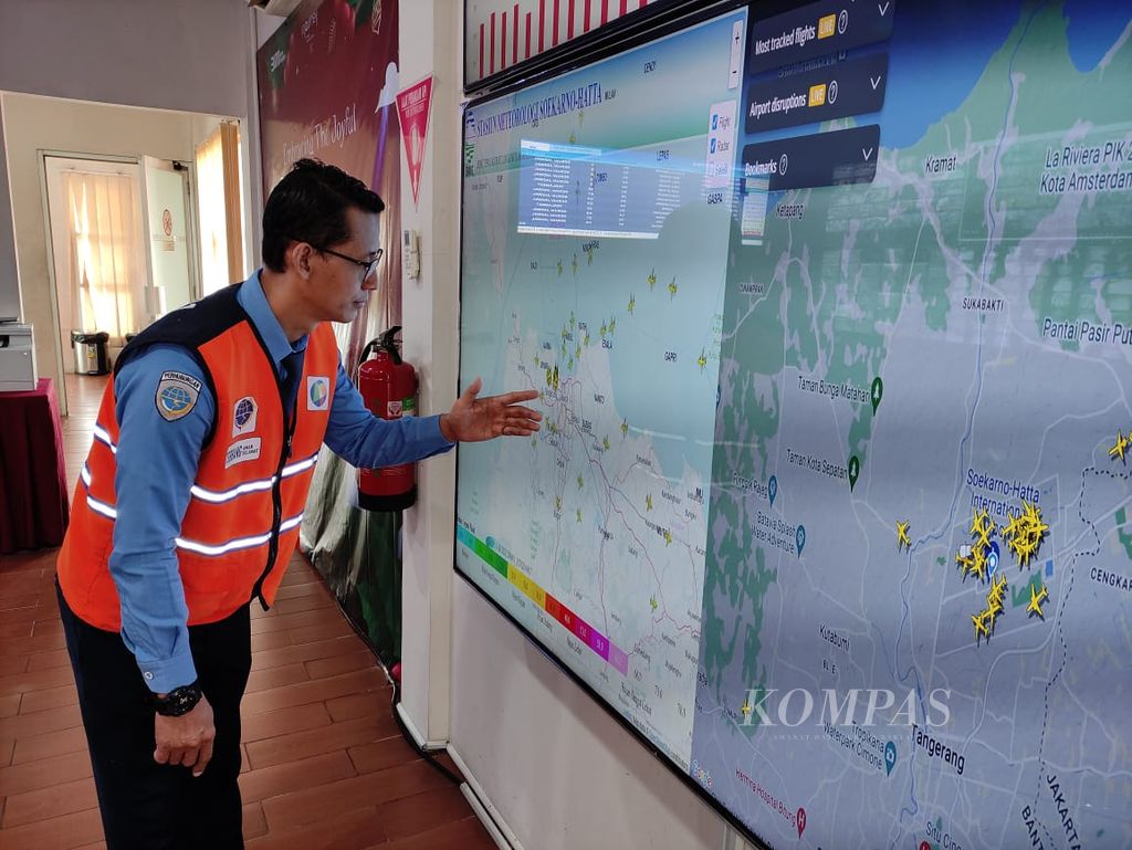 Petugas Posko Terpadu Angkutan Natal dan Tahun Baru Bandara Soekarno-Hatta mengamati layar yang menayangkan jalur pesawat di Tangerang, Banten, Senin (18/12/2023).