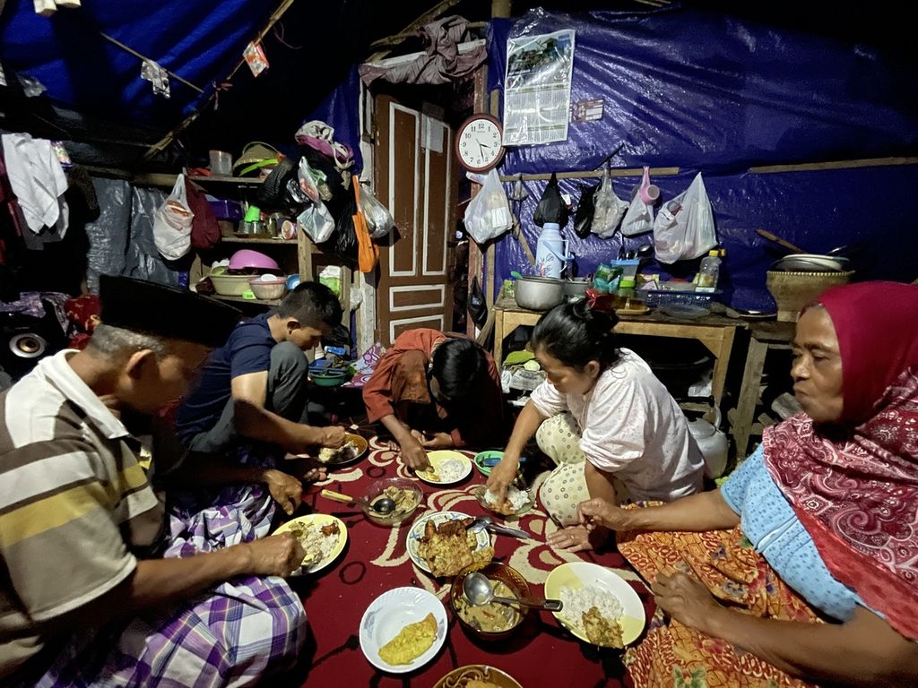 Suasana sahur di dalam tenda salah satu pengungsi di Kampung Kawunggading, Desa Cibulakan, Kecamatan Cugenang, Kabupaten Cianjur, Jawa Barat, Jumat (24/3/2023). Kata<i> sahur</i> bukanlah akronim <i>sarapan khusus Ramadhan</i>. 