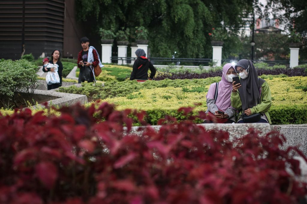 Warga menikmati suasana taman di Alun-alun Kota Bandung, Jawa Barat, Rabu (5/4/2023).