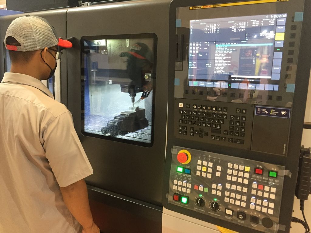 Salah seorang anggota staf mengoperasikan mesin bubut digital saat pameran Manufacturing Surabaya di Grand City Convention & Exhibition, Surabaya, Jawa Timur, Rabu (13/7/2022).