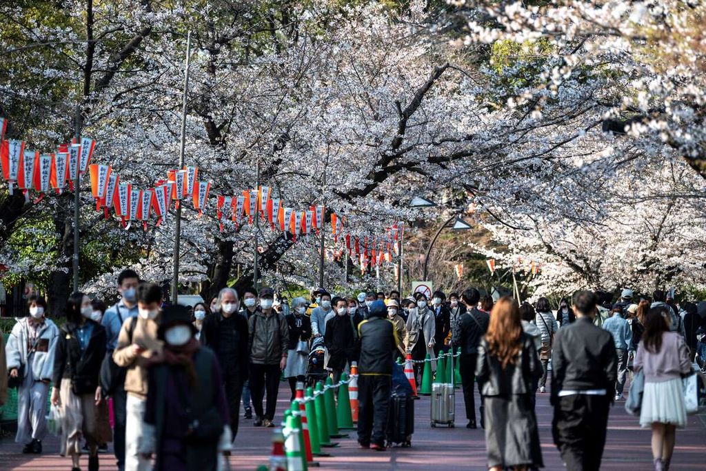 Warga menikmati pohon sakura yang tengah bermekaran di sebuah taman di Tokyo, Jepang, Selasa (23/3/2021). Di Tokyo, musim sakura bisa muncul paling cepat 15 Maret dan mencapai puncak mekar pada 23 Maret atau 11 hari lebih cepat dari jadwal biasanya. 