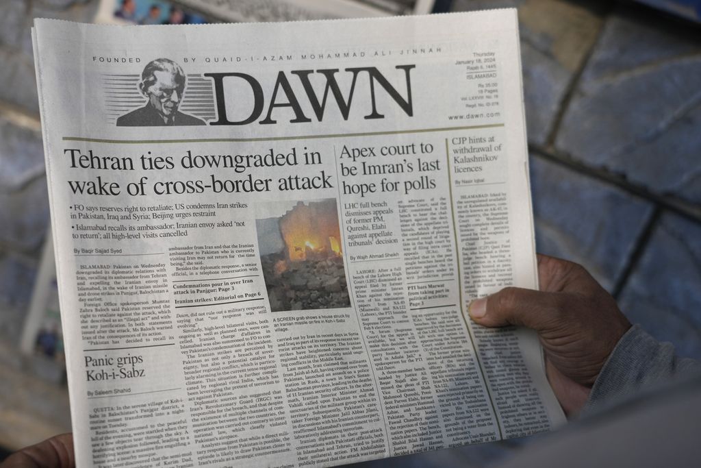 Seorang warga membaca surat kabar Pakistan yang memuat berita serangan Iran, di sebuah kios di Islamabad, Pakistan, 18 Januari 2024. 