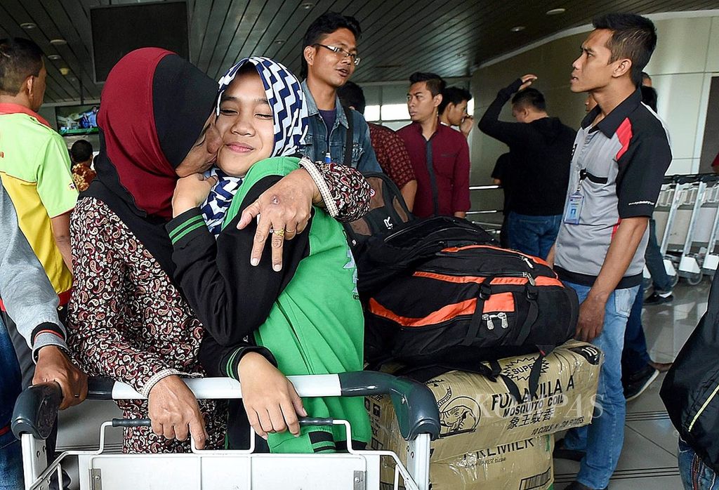 Sholehah (50) (kiri) mencium anaknya, Dewi (15), setibanya dari Malaysia di Terminal 2 Bandara Juanda, di Sidoarjo, Jumat (24/6). Setelah empat tahun bekerja di Malaysia, Sholehah pulang untuk berlebaran di Kampungnya di Paiton, Kabupaten Probolinggo.