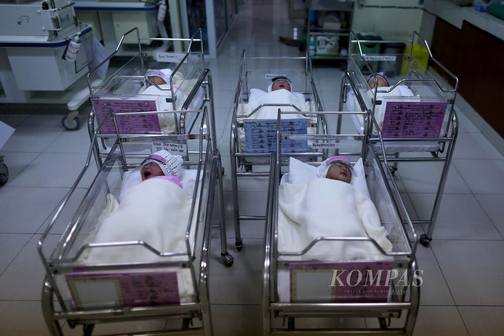 Bayi yang baru lahir terlelap di ruang bayi Rumah Sakit Ibu dan Anak Tambak, Jakarta, dengan menggunakan pelindung wajah (<i>face shield</i>), Senin (20/4/2020). 