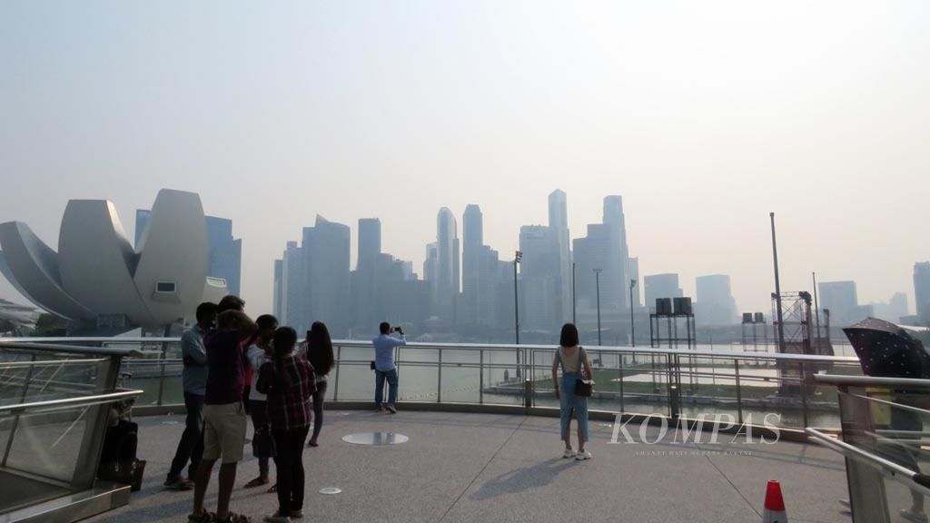 Kabut asap akibat kebakaran lahan di Sumatera masih menyelimuti wilayah Singapura (16/9/2019) seperti yang terlihat di lokasi wisata ikonik Jembatan Helix di Marina Bay. 