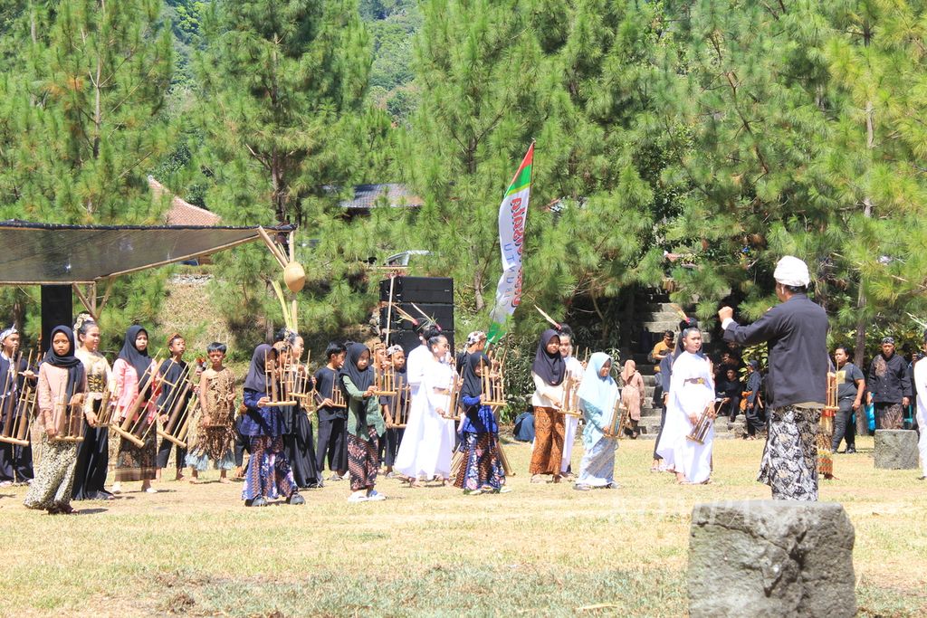 Sejumlah anak bermain angklung dalam acara Sedekah Bumi di Desa Cibuntu, Kecamatan Pasawahan, Kabupaten Kuningan, Jawa Barat, Sabtu (7/9/2024). Selain melestarikan tradisi, kegiatan itu juga untuk menarik kunjungan wisatawan. Sejak 2012, Cibuntu yang daerahnya bekas galian C mulai menjelma menjadi desa wisata.