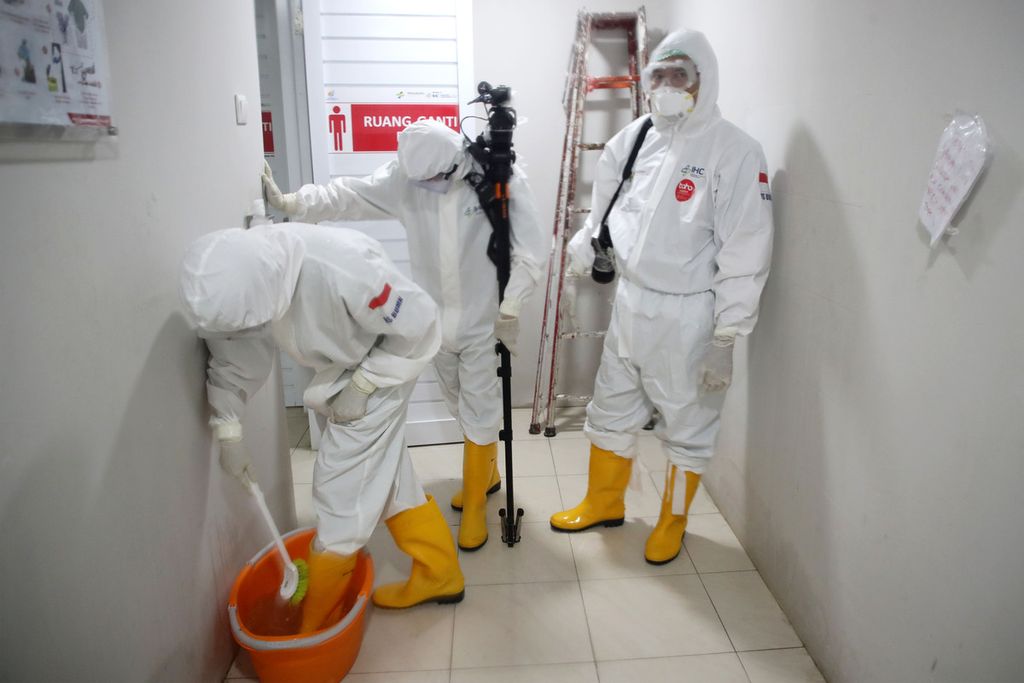 Membersihkan sepatu dan melepaskan alat pelindung diri (APD) lain di ruang khusus seusai peliputan di Rumah Sakit Pertamina Jaya, Jakarta, Kamis (30/4/2020). 