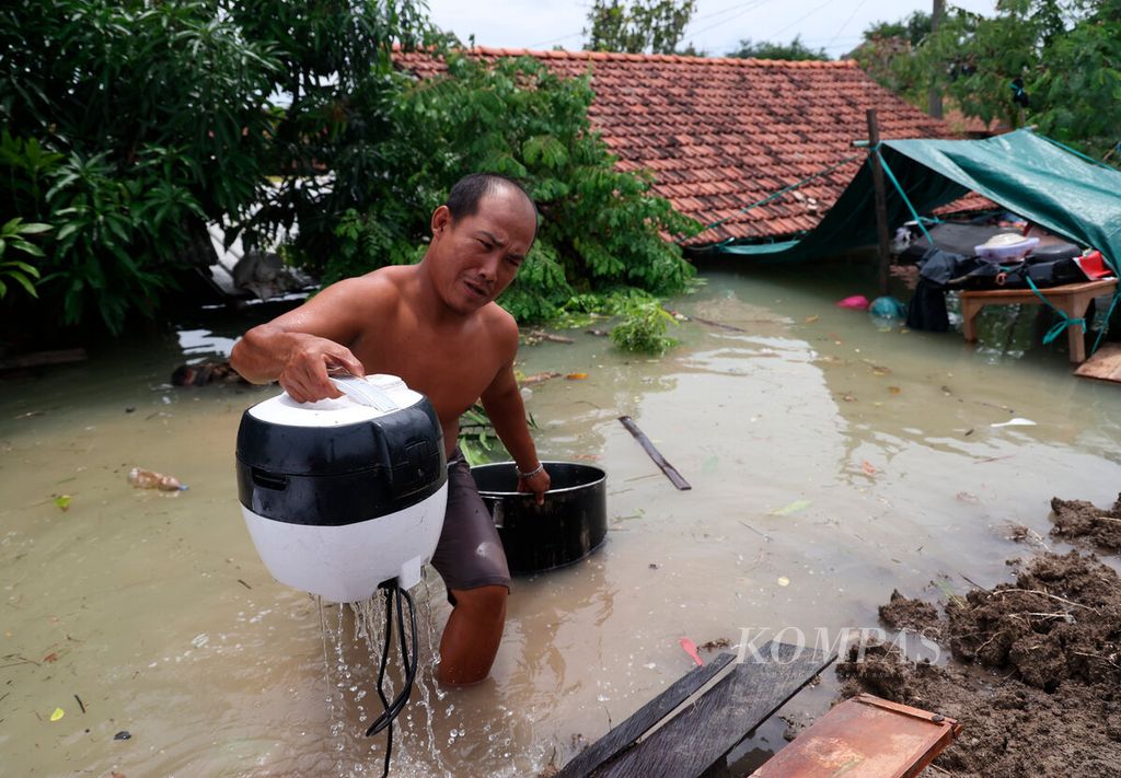 Warga berusaha menyelamatkan harta bedanya setelah banjir kembali menggenangi rumah mereka di Desa Ketanjung, Kecamatan Karanganyar, Kabupaten Demak, Jawa Tengah, Minggu (17/3/2024). 