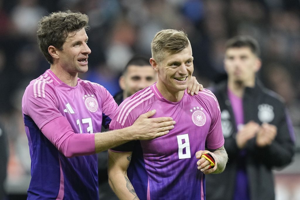 Pemain Jerman, Thomas Mueller (kiri) dan Toni Kroos, tersenyum usai laga persahabatan melawan Belanda di Deutsche Bank Park, Frankfurt, Jerman, Selasa (24/3/2024). Jerman menang 2-1 pada laga itu.