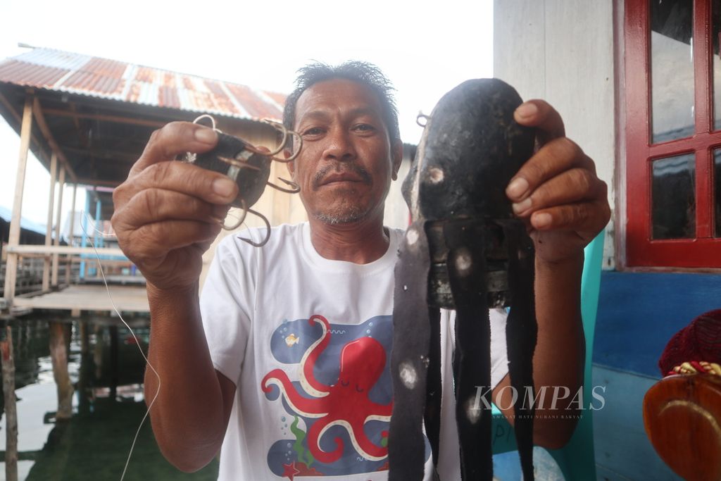 Moji Tiok (50) shows a pocong, an octopus fishing gear, in Torosiaje Village, Popayato District, Pohuwato Regency, Gorontalo, Friday (15/7/2022). The fishing gear is environmentally friendly because it does not damage coral reefs. The village government of Torosiaje plans to limit the capture of octopuses to maintain the animal's population.