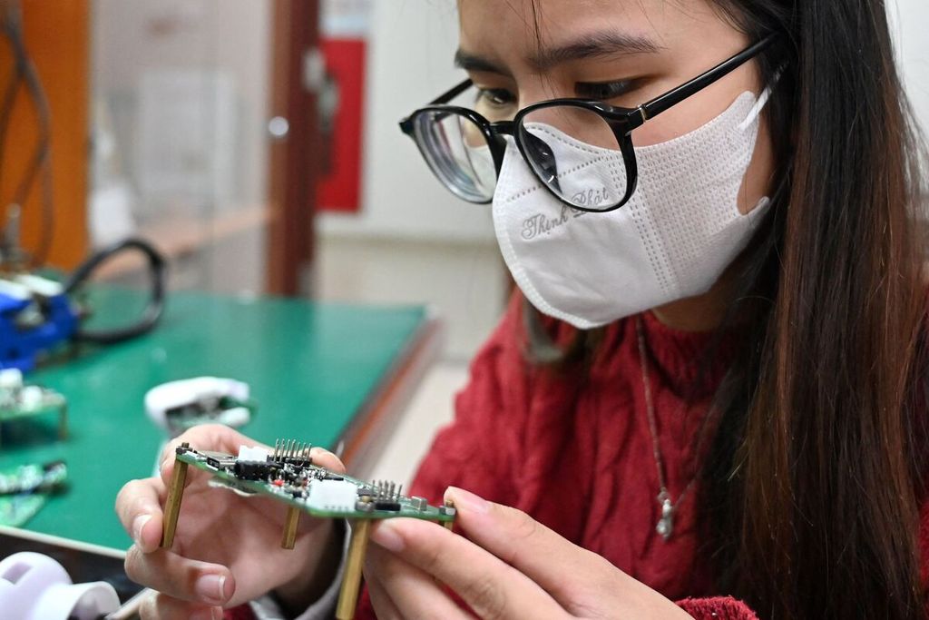 Dalam foto pada 1 Maret 2024 ini, mahasiswi Hanoi University of Science and Technology mempelajari papan semikondukor. 