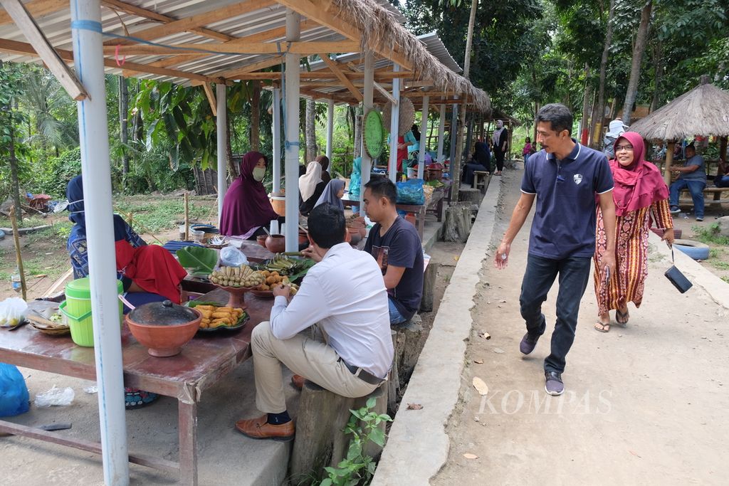 Pengunjung menikmati berbagai jenis jajanan tradisional yang dijual warga di Pasar Pancingan, Desa Wisata Hijau Bilebante, Kecamatan Pringgarata, Kabupaten Lombok Tengah, Nusa Tenggara Barat, Minggu (26/7/2020).