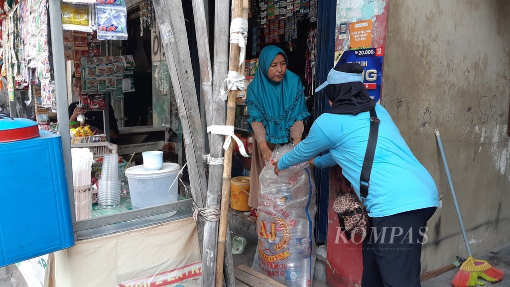 Petugas Bank Sampah Kenanga RW 004, Kelurahan Semper Barat, Cilincing, Jakarta Utara, menerima sampah yang dikumpulkan anggotanya, Kamis (27/7/2023). 