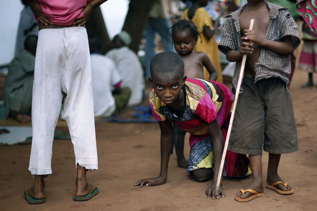 Hamamatou Harouna (10), kehilangan fungsi kakinya karena polio, merangkak ke kamar kecil di halaman gereja di Carnot, Republik Afrika Tengah, pertengahan April 2014. 