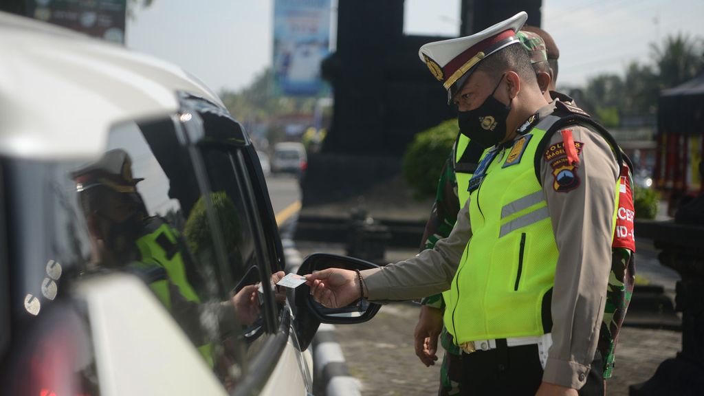 Polisi memeriksa KTP dan kelengkapan dokumen perjalanan pengguna mobil berpelat nomor luar daerah di perbatasan Jawa Tengah-DI Yogyakarta, Kecamatan Salam, Magelang, Jawa Tengah, Kamis (6/5/2021). 