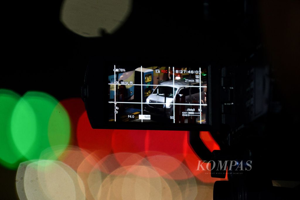 Pengendara mobil membayar e-tol terlihat dari layar kamera seorang jurnalis yang meliput di Pos Jasa Marga, Gerbang Tol Cikampek Utama, Karawang, Jawa Barat, Minggu (30/4/2023). 