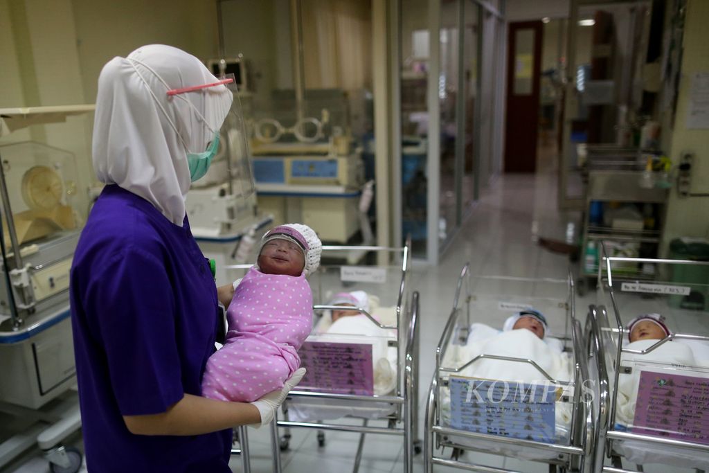 Perawat mengontrol bayi yang baru lahir di ruang bayi Rumah Sakit Ibu dan Anak Tambak, Jakarta, Senin (20/4/2020). Baik bayi maupun perawat mengenakan pelindung wajah (face shield). Kebijakan internal pemasangan pelindung wajah pada bayi yang baru lahir ini dilakukan untuk meminimalkan bayi terpapar virus korona baru melalui <i>droplet</i>.