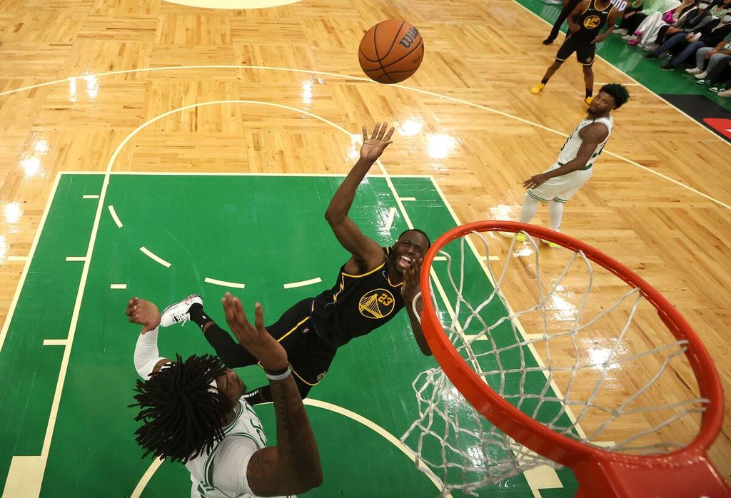 Pemain Golden State Warriors Draymond Green (tengah) melempar bola ke basket dengan diadang pemain Boston Celtics Robert Williams III (kiri) pada laga keempat final NBA di TD Garden, Boston, Sabtu (11/6/2022). Pada laga itu Warriors menang dengan skor 107-97 dan membuat kedudukan imbang 2-2. 