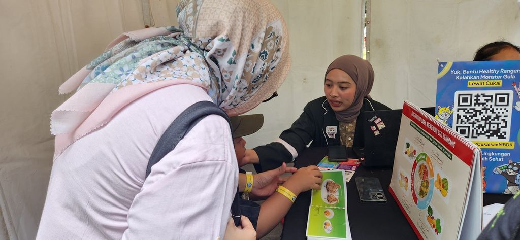 Seorang penyuluh kesehatan memberikan edukasi dan informasi mengenai gizi seimbang yang baik untuk tumbuh kembang anak kepada pengunjung yang datang di kegiatan PHC Fest di Jakarta, Sabtu (13/7/2024).