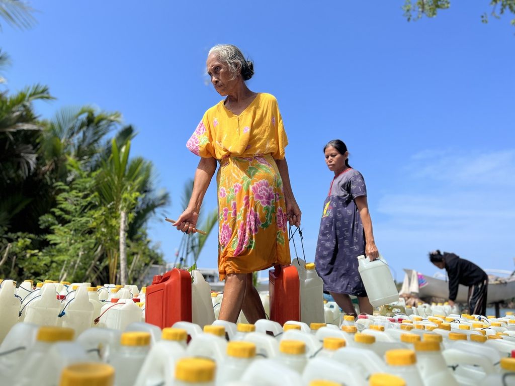 Hadia (65) mengangkat jeriken berisi air bersih di muara Sungai Mandar, Polewali Mandar, Sulawesi Barat, Jumat (15/9/2023). Air ini akan dijual untuk keperluan air bersih.