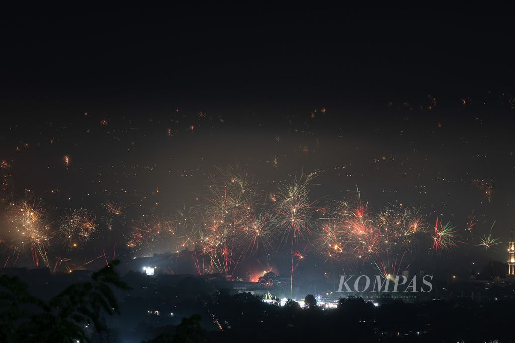 Warga di sekitar kompleks Candi Prambanan, Sleman, DI Yogyakarta, menyalakan kembang api untuk merayakan Tahun Baru 2023, Minggu (1/1/2023).