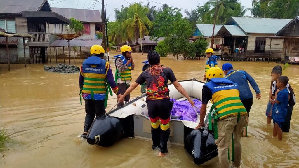 Petugas membagikan makanan kepada warga korban banjir di Desa Sungai Raya, Kecamatan Simpang Empat, Kabupaten Banjar, Kalimantan Selatan, Kamis (13/1/2022).