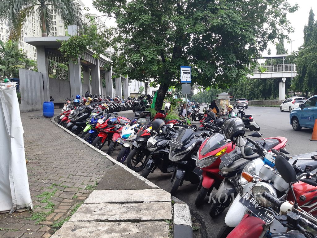 The condition of the sidewalk which is cramped with illegal parking in front of the Kalibata City apartment, South Jakarta, Sunday (3/3/2024). Pedestrians feel disturbed by this activity.