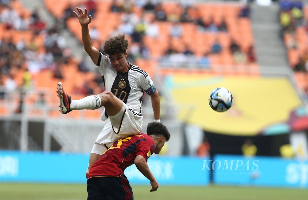Pemain Spanyol, Quim Junyent (bawah), berebut bola dengan kapten Jerman, Noah Darvich, dalam laga perempat final Piala Dunia U-17 2023 di Stadion Internasional Jakarta (JIS), Jakarta, Jumat (24/11/2023). 