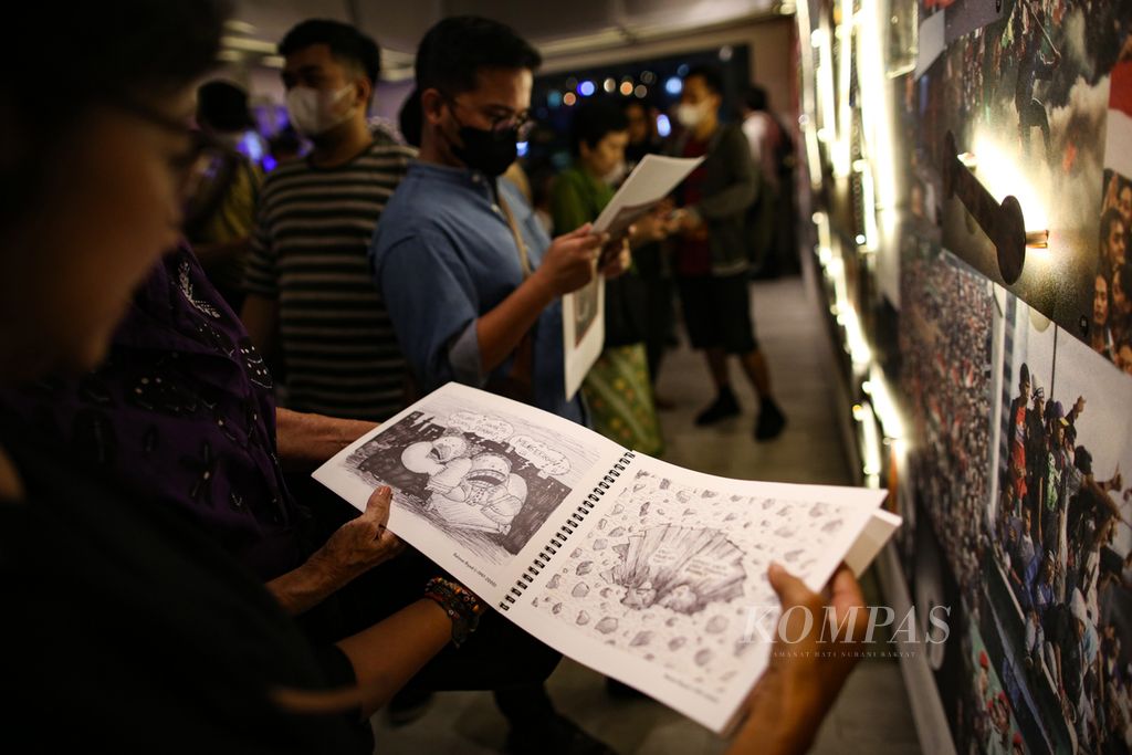 Pengunjung menyaksikan arsip karikatur dalam pembukaan pameran "25 TAHUN REFORMAS!H IN ABSENTIA" di Yayasan Riset Visual mataWaktu di Jakarta, Rabu (17/3/2023) malam.