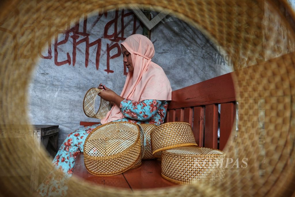 Ibu rumah tangga yang bekerja untuk UMKM peci rajut Mustofa menyelesaikan pembuatan peci rajut di rumahnya di Desa Pleret, Kecamatan Pleret, Bantul, DI Yogyakarta, Selasa (26/3/2024). 
