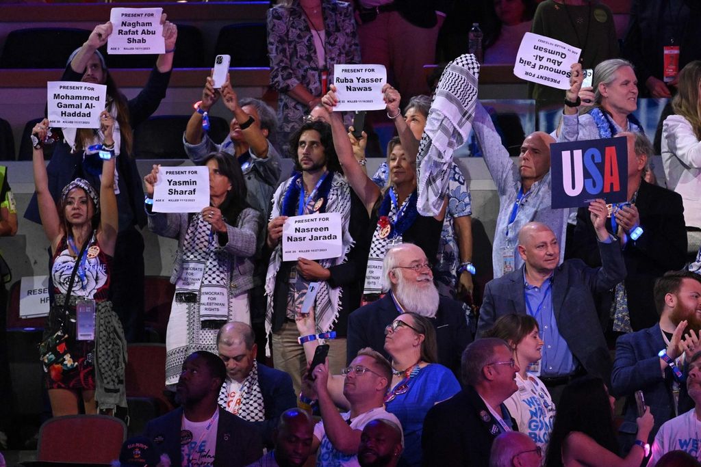 Sejumlah delegasi mengenakan kafiyeh dan mengangkat tulisan berisi nama-nama warga Palestina yang tewas dalam perang Gaza saat mereka menghadiri Konvensi Nasional Demokrat (DNC) di United Center di Chicago, Illinois, AS, pada hari kedua, 20 Agustus 2024. 