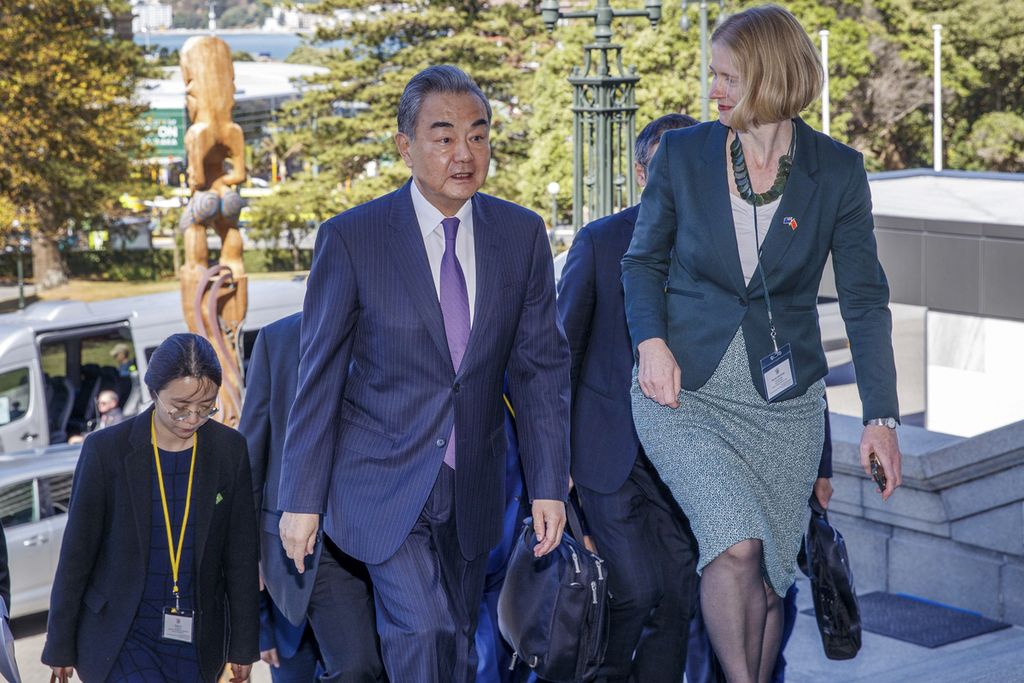 Menteri Luar Negeri China Wang Yi (tengah) dipandu saat menaiki tangga parlemen oleh Manajer Divisi Asia Utara Kementerian Luar Negeri dan Perdagangan Selandia Baru Wendy Matthews (kanan), sebelum pertemuan bilateral di Wellington, Selandia Baru, Senin (18/3/2024). 