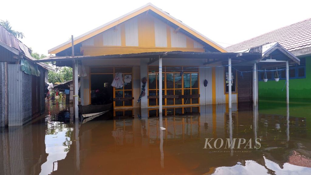 Warga menambat perahu di dalam rumahnya di Kelurahan Sungai Lulut, Kecamatan Banjarmasin Timur, Kota Banjarmasin, Kalimantan Selatan, Minggu (24/1/2021). Hampir dua pekan permukiman warga di tepian Sungai Lulut, anak Sungai Martapura, itu dilanda banjir.