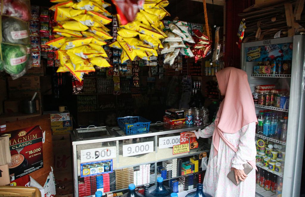 Warga berbelanja di warung kelontong di daerah Pisangan, Ciputat Timur, Tangerang Selatan, Banten, Selasa (8/11/2022). Warung kelontong madura yang buka 24 jam mampu bersaing dengan minimarket yang menjamur. Harga yang lebih murah dari minimarket menjadi salah satu daya tariknya. 