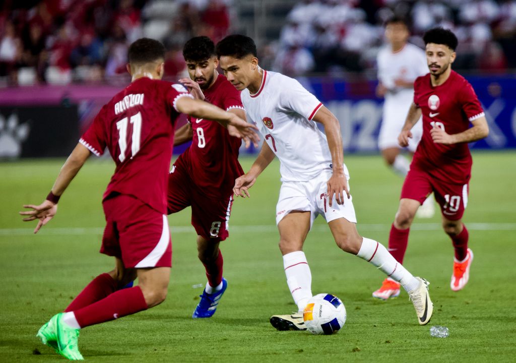 Gelandang Indonesia, Marselino Ferdinan, menguasai bola di tengah kepungan pemain Qatar pada laga pertama Grup A Piala Asia U-23 2024, Senin (15/4/2024), di Stadion Jassim bin Hamad, Al Rayyan, Qatar. Indonesia kalah 0-2.