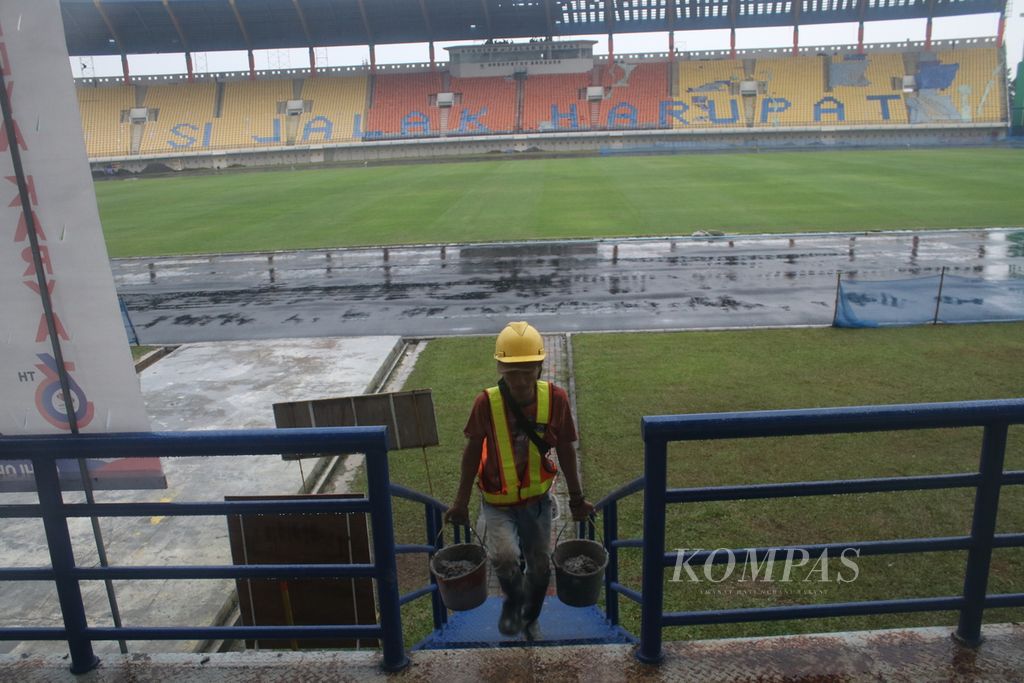 Pekerja mengangkat semen untuk merenovasi beberapa bagian Stadion Si Jalak Harupat di Kecamatan Soreang, Kabupaten Bandung, Jawa Barat, Senin (20/3/2023).