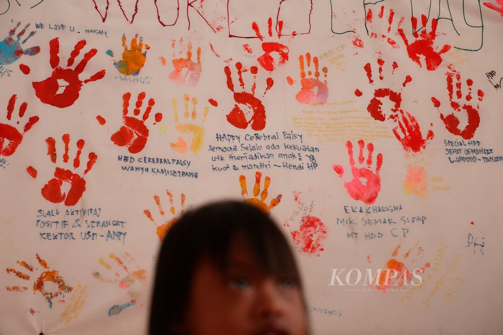 Anak berkebutuhan khusus dengan latar belakang papan yang berisi pesan dan kesan di Rumah Terapi Disabilitas Anak, Kecamatan Semarang Barat, Kota Semarang, Jawa Tengah, Februari 2022. 