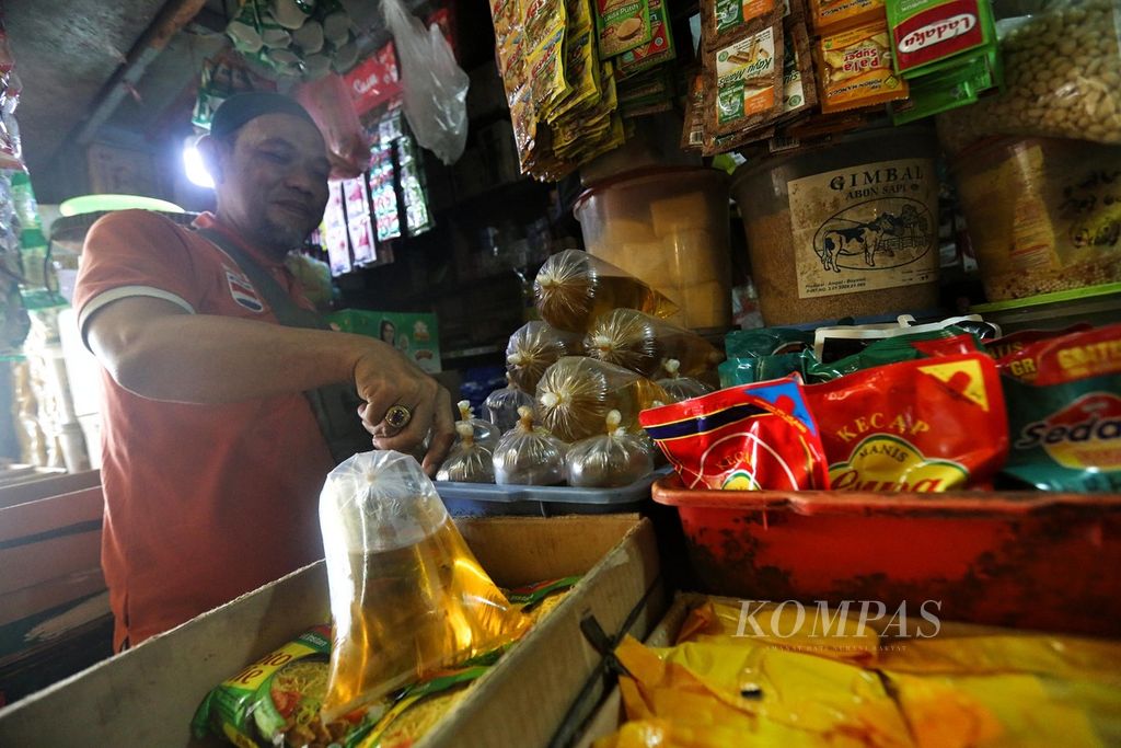 Rauf, pedagang bahan pokok di Pasar Kebayoran Lama, Jakarta Selatan, Senin (24/1/2022), menunjukkan stok minyak goreng curah. 