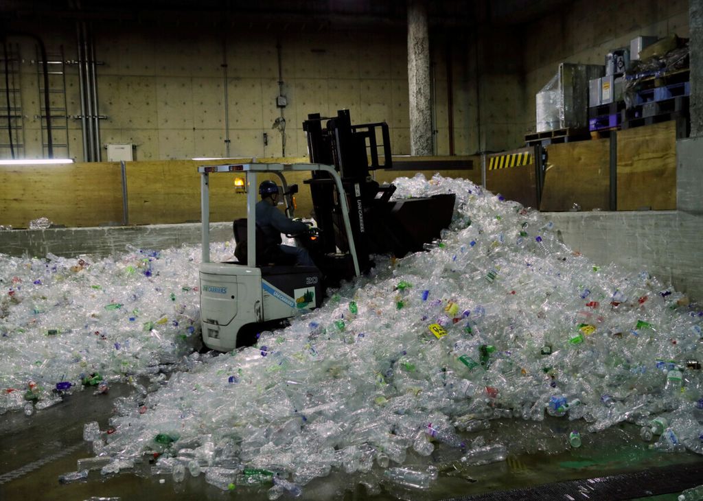 Sebuah<i> forklift </i>mengangkut botol plastik untuk didaur ulang di Minato Resource Recycle Center di Tokyo, Jepang, Senin (10/6/2019).