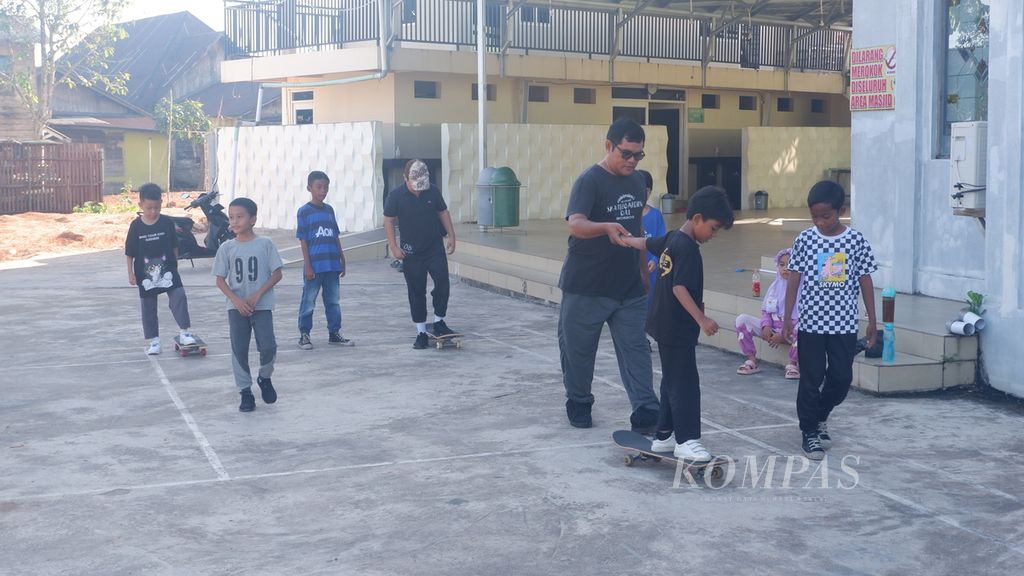 Anak-anak berlatih permainan papan seluncur atau <i>skateboard</i> di halaman Masjid Al-Haq, Kelurahan Banua Anyar, Kecamatan Banjarmasin Timur, Kota Banjarmasin, Kalimantan Selatan, Minggu (11/6/2023).