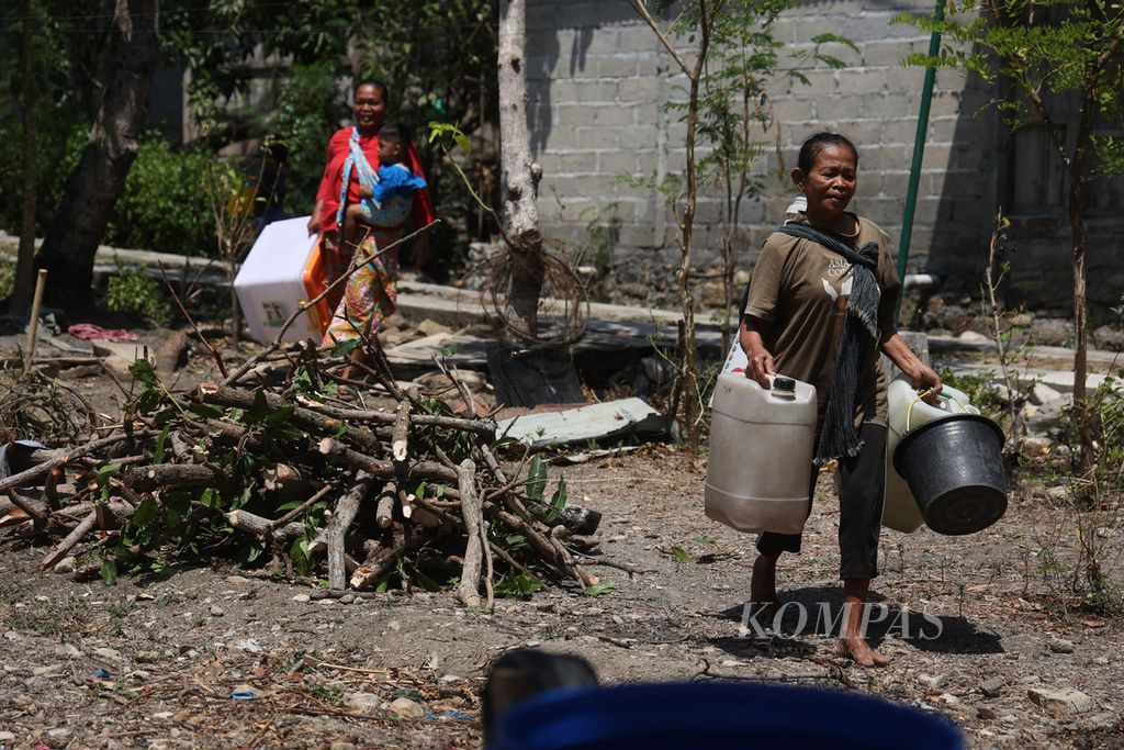 Warga membawa wadah untuk menampung bantuan air bersih di Dusun Kalilantung, Desa Bengle, Kecamatan Wonosamodro, Boyolali, Jawa Tengah, Selasa (19/9/2023). 