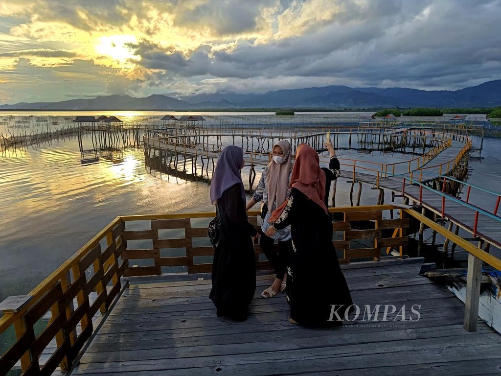 Wisatawan menikmati suasana senja di alo cinta, lokasi melihat matahari tenggelam, di Kampung Bajo Torosiaje, Kabupaten Pohuwato, Gorontalo, Sabtu (16/7/2022).