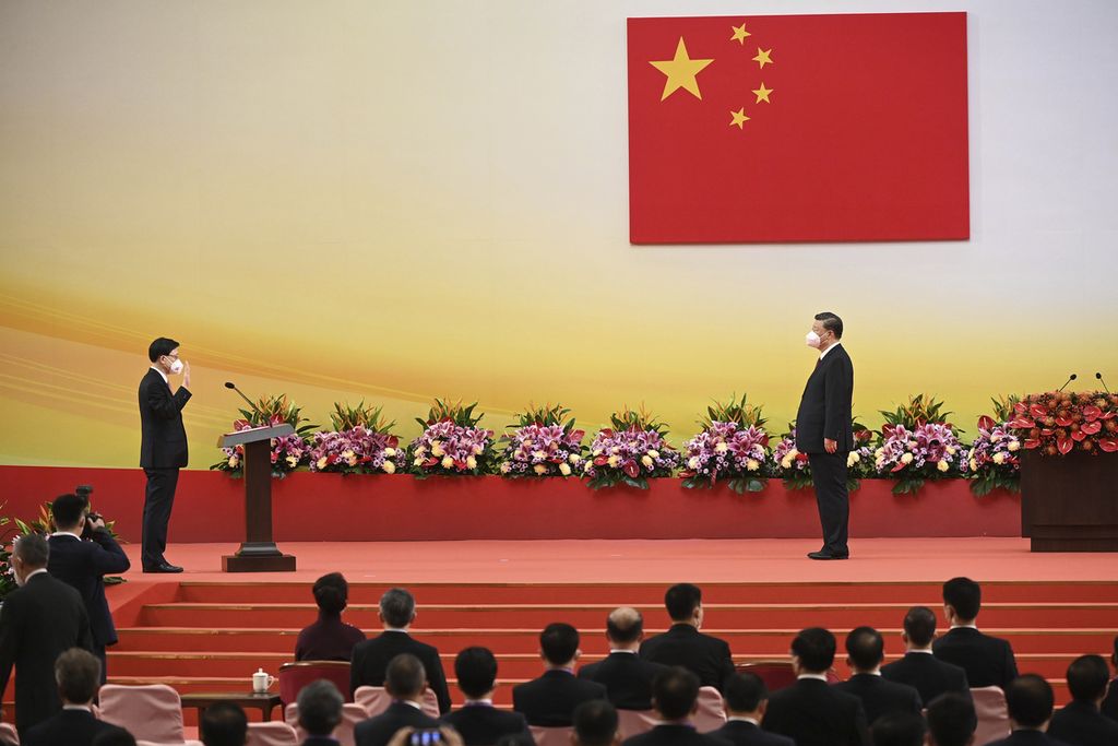 Presiden China Xi Jinping (kanan) melihat ke arah Pemimpin Eksekutif Hong Kong John Lee dalam upacara  pelantikan pemerintahan baru Hong Kong, 1 Juli 2022, saat peringatan 25 tahun penyerahan Hong Kong dari Inggris kepada China. 