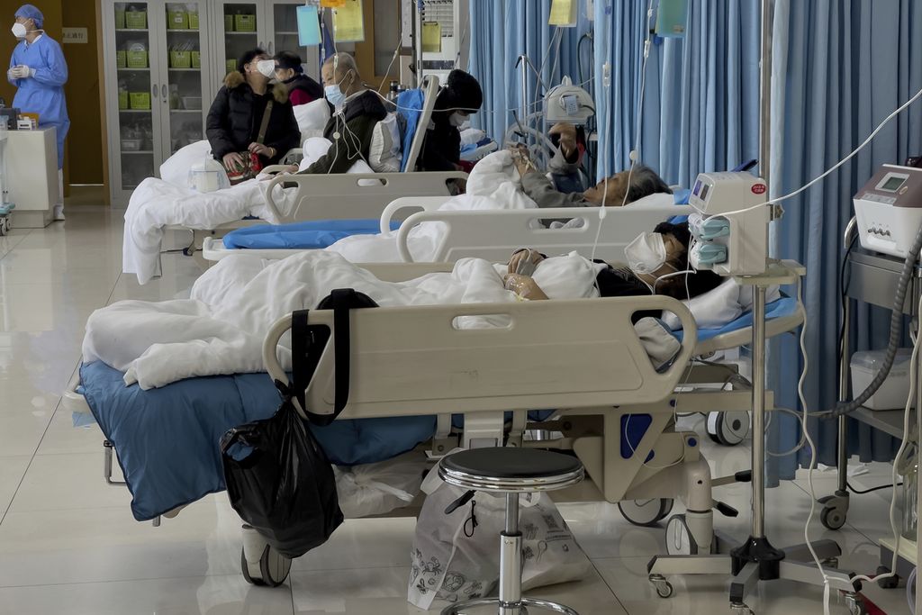 Orang-orang Tampa sedang membesuk kerabat lansia mereka yang sedang dirawat di aula darurat sebuah rumah sakit di Beijing, Sabtu (7/1/2023). 