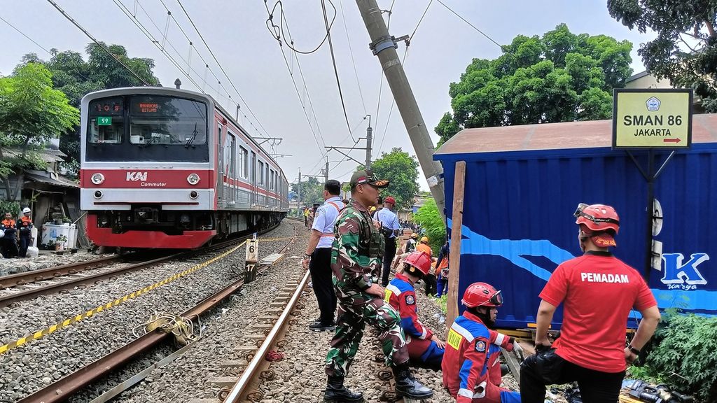 Kereta dari arah Rangkasbitung melintas di lajur hulu berjalan lambat karena proses evakuasi truk barang yang menabrak tiang listrik aliran atas (LAA) di jalur rel listrik di Km 17+5 antara Stasiun Pondok Ranji dan Kebayoran, Jalan Bintaro Permai IV, Pesanggrahan, Jakarta Selatan, Selasa (25/7/2023).
